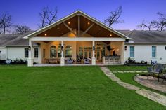 a large white house sitting on top of a lush green field