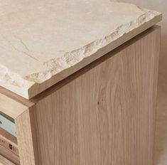 a close up of a wooden cabinet with a marble top and drawers on each side