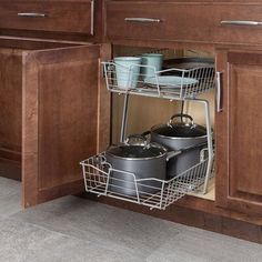 an open cabinet with pots and pans in it