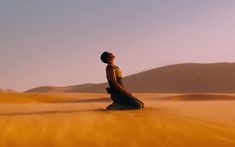 a person sitting in the middle of a desert