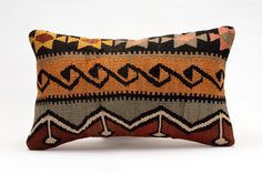 a decorative pillow made from an old kilim cloth with geometrical design on the front