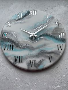 a clock that is on the side of a wall with roman numerals and water