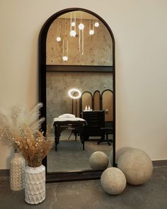 a mirror sitting on top of a table next to two vases