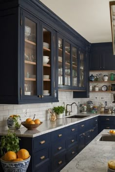 a kitchen with blue cabinets and marble counter tops