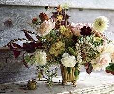 a vase filled with lots of flowers sitting on top of a table