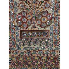 an intricately decorated wall hanging in the shape of a face with many circles and flowers