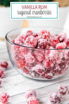 a glass bowl filled with sugared cranberries on top of a wooden table