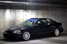 a black car parked in front of a wall