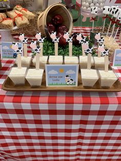 a table topped with lots of food on top of a red and white checkered table cloth