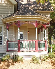 a small white house with a red porch