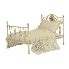 an antique white metal bed with lacy bedspread