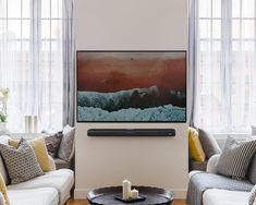 a living room filled with furniture and a flat screen tv mounted on the wall over a fireplace