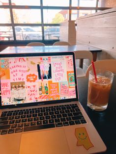 an open laptop computer sitting on top of a table next to a cup of coffee