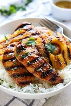 grilled chicken and pineapples with coconut rice in a white bowl