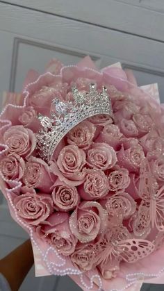 a bouquet of pink roses with a tiara on top