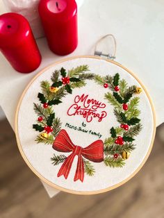 a cross stitch christmas wreath with red candles