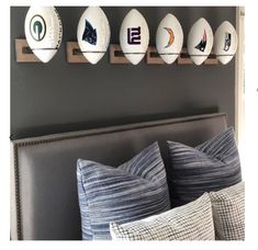 a bed room with a neatly made bed and wall mounted sports balls on the wall