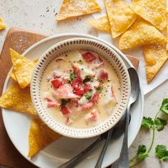 a bowl of soup with tortilla chips on the side and garnish