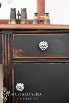 an old black dresser with knobs on it