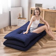 a woman sitting on top of a blue bean bag chair