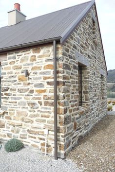 an old stone building with a metal roof