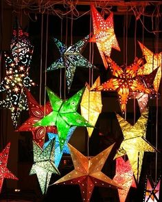 many different colored stars hanging from strings