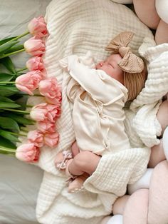 a baby is sleeping on a blanket with pink flowers