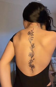 the back of a woman's body with flowers on her upper and lower back