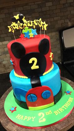 a birthday cake with mickey mouse decorations on it's face and number two on top