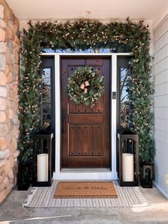 the front door is decorated with greenery and wreaths