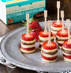 there are mini sandwiches with strawberries on them and toothpicks sticking out of them