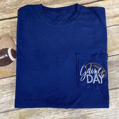 Looking for a shirt to show your support on game day? Look no further than the Game Day Football Pocket Shirt! This comfortable long sleeve shirt is perfect for those chilly fall days spent cheering on your team. The game day and football embroidery on the pocket adds a fun and festive touch, while the relaxed fit ensures you'll be comfortable all day long. Whether you're tailgating or watching the game from home, this shirt is sure to help you show your team pride. Football Embroidery, Fall Days, Pocket Shirt, Comfort Colors, The Game, From Home