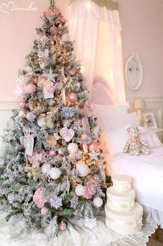 a decorated christmas tree with pink and silver ornaments in a girls'bedroom, next to a white bed