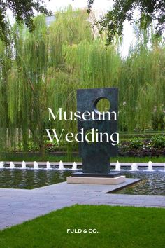 the museum wedding sign is in front of a pond and willow tree with water lilies