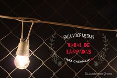 two light bulbs hanging from a chain link fence with the words karal de lampadas on it