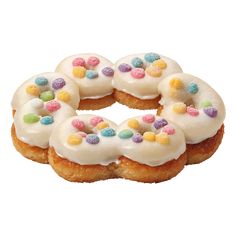 six donuts with white frosting and colorful candies