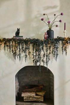 Faux evergreen branches in a striking black hue create the dramatic, dripping silhouette of this garland, perfect for styling on the mantel. Warm white LEDs peek through the foliage for a soft glow. | LED Cascading Black Boughs Garland at Terrain Woodsy Halloween Decor, Halloween Decorations Indoor Minimalist, Neutral Halloween Mantle, Practical Magic Decor Inspiration, Dark Fall Decor, Halloween Decor Fireplace, Black Fall Decor, Gothic Halloween Decor, Halloween Living Room Decor