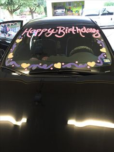 a car with a happy birthday sign on the windshield