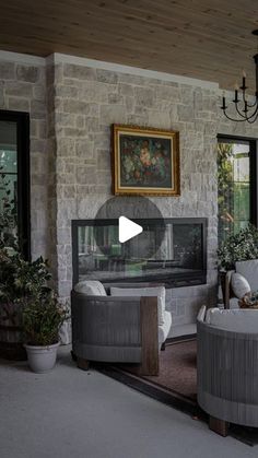 a living room filled with furniture and a chandelier hanging from the ceiling next to windows