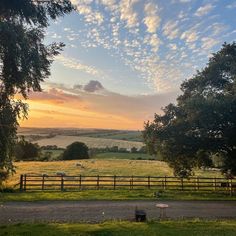 the sun is setting over an open field