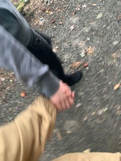 two people walking down a road with their feet in the air