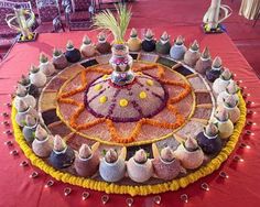 a table topped with lots of vases filled with flowers and candles on top of a red table cloth