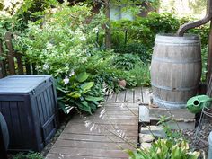 a wooden walkway leading to a barrel in the middle of a garden