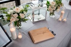 a table with candles, flowers and a notepad on it that says wedding written in cursive writing