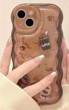 a woman holding up a cell phone case with an image of a cupcake on it