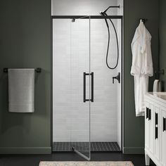 a bathroom with a walk in shower next to a white sink and black framed mirror