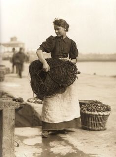 an old black and white photo of a woman with baskets