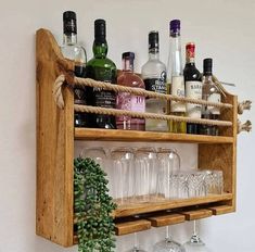 a wooden shelf with wine glasses and liquor bottles