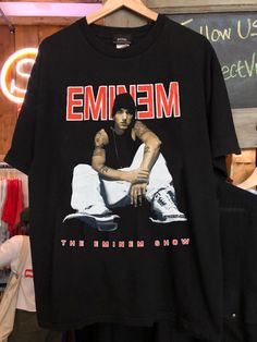 a black t - shirt with the words meme on it and a man sitting down