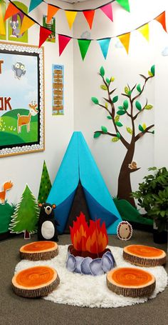 there is a tent and some trees in the room that has decorations on the walls